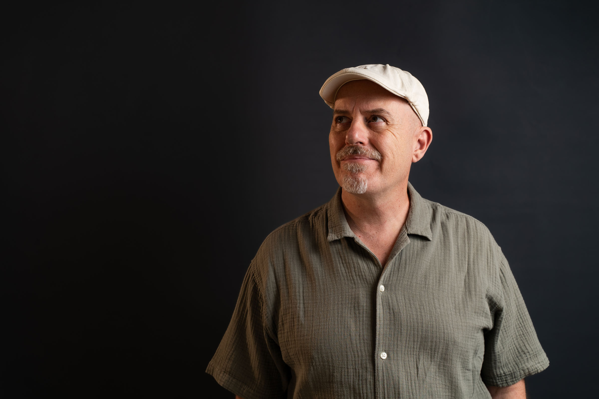 Retrato de Poti de Cai con gorra blanca, sobre fondo oscuro